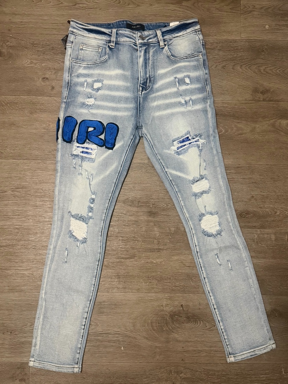 AMIRI Light Wash Distressed Slim Fit Jeans with Blue Patch Logo